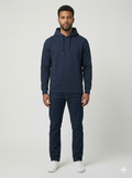 Man wearing a navy hoodie and pants on a white background