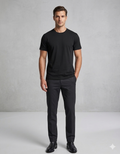 Man wearing a black t-shirt and dark pants against a gray background