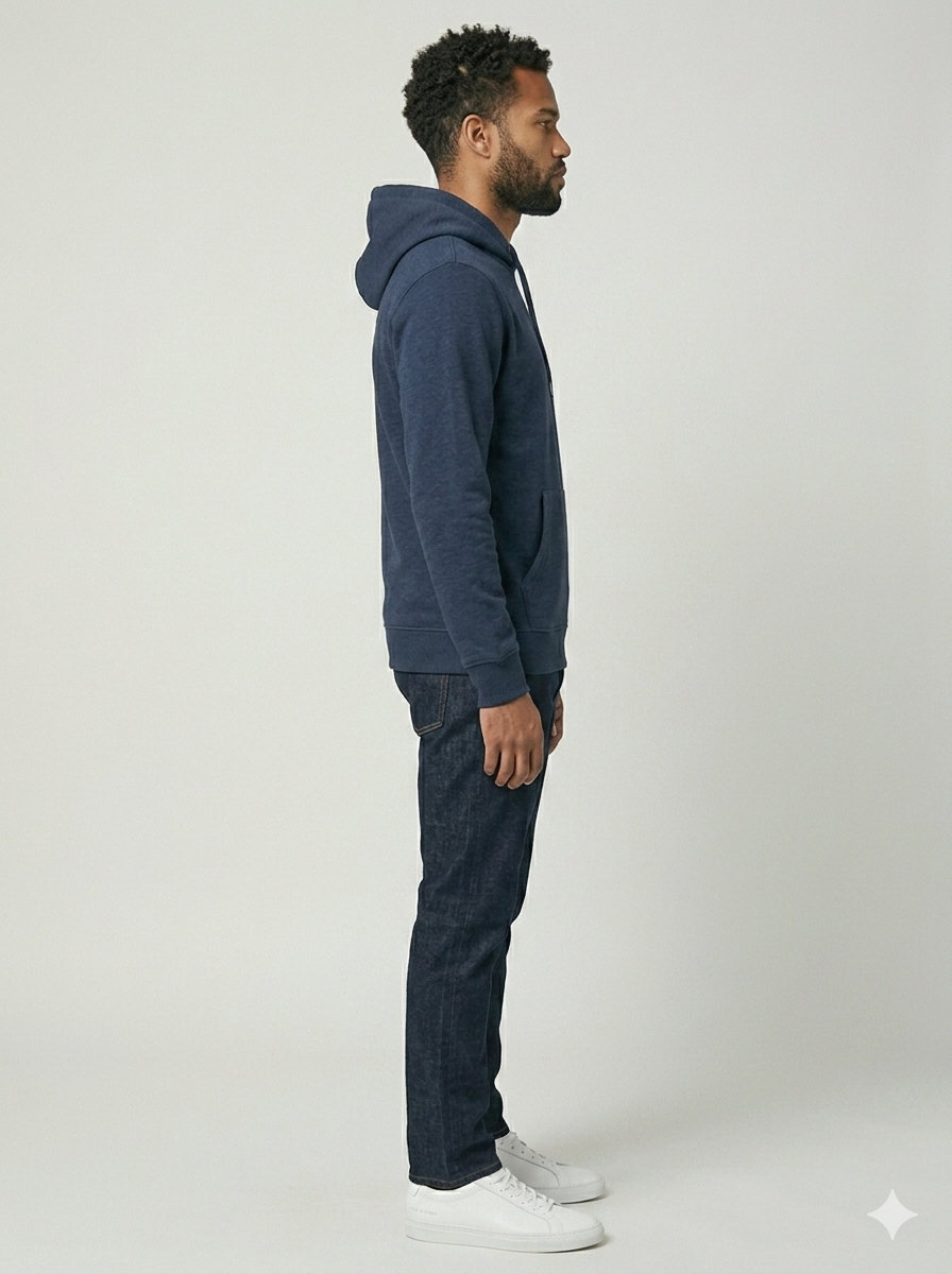 Man wearing a blue hoodie and jeans standing against a white background